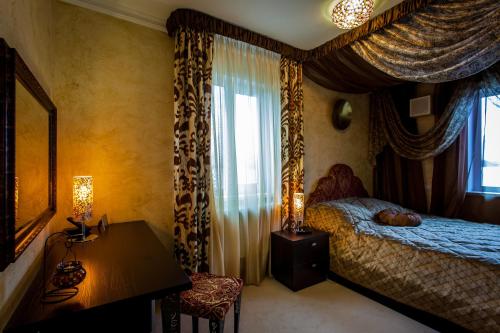 ニジニ・ノヴゴロドにあるHotel Fondaのベッドルーム1室(ベッド1台、テーブル、窓付)