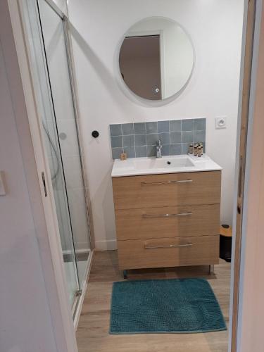 une salle de bain avec un lavabo et un miroir dans l'établissement La plage logement de tourisme meublé - 3 étoiles, à Villers-sur-Mer