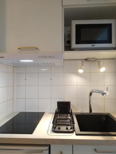 a kitchen with a sink and a stove and a microwave at Au coeur d'Anglet, Studio Oihana - Plage et Biarritz à 10 min in Anglet