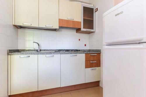 uma cozinha branca com um lavatório e um frigorífico em Apartment in Lignano 21640 em Lignano Sabbiadoro