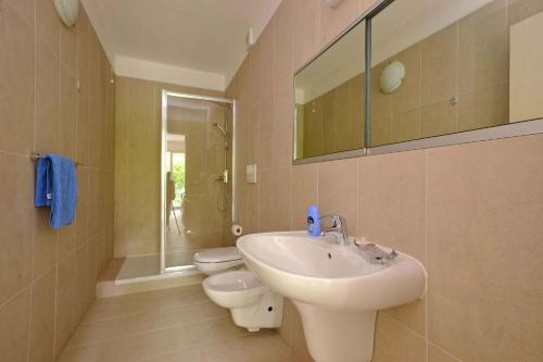リニャーノ・サッビアドーロにあるApartments in Lignano 21708のバスルーム(洗面台、トイレ、鏡付)