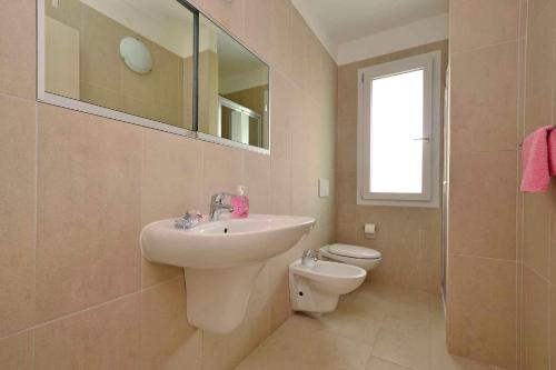 リニャーノ・サッビアドーロにあるApartments in Lignano 21589のバスルーム(洗面台、トイレ、鏡付)
