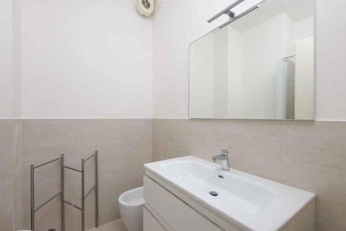 リニャーノ・サッビアドーロにあるApartments in Lignano Sabbiadoro 21788のバスルーム(洗面台、トイレ、鏡付)