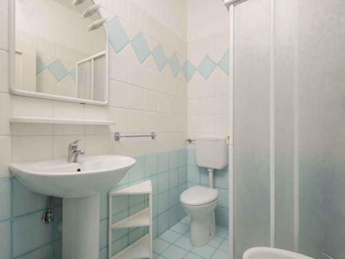 bagno con lavandino e servizi igienici di Apartments in Lignano Sabbiadoro 21784 a Lignano Sabbiadoro
