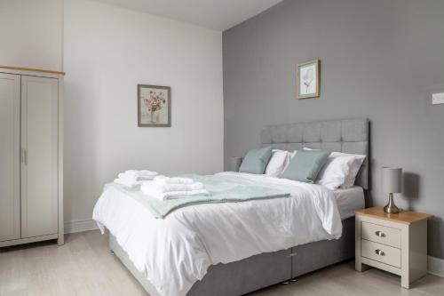 a bedroom with a large bed with towels on it at Glan Conwy House One and Two Bedroom Apartments in Llanrwst