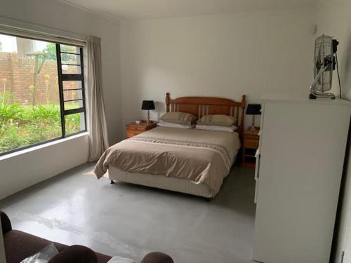 a bedroom with a bed and a large window at Bromely Loft in Port Alfred