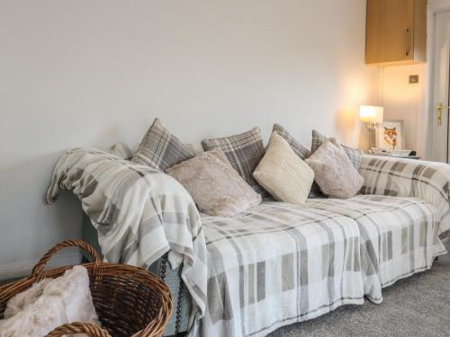 a living room with a couch with pillows at The Foxes Den in Totmonslow