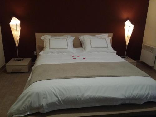 マントンにあるLes Citronniers d'Azurのベッドルーム(白い大型ベッド、ランプ2つ付)