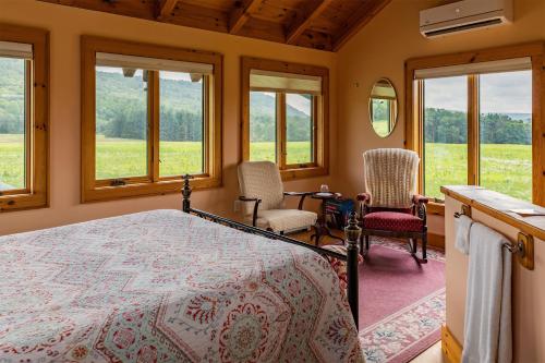 - une chambre avec un lit, 2 chaises et des fenêtres dans l'établissement Tenwood Lodge, à Ithaca
