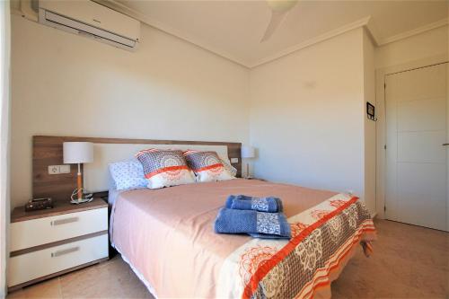 Un dormitorio con una cama con una toalla azul. en Beautiful house in Campoamor Golf, en Villacosta