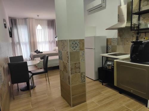 a kitchen with a table and a room with a bed at Hotel Apartamentos Pueblo Mar in Calpe