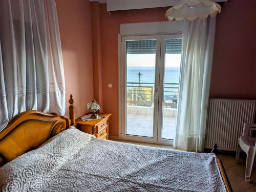 a bedroom with a bed and a view of the ocean at Lichnides Maisonette in Mola Kalyva