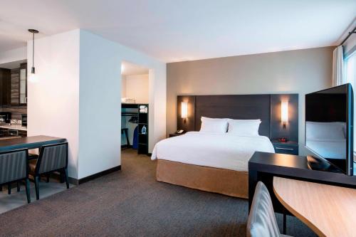 a hotel room with a bed and a kitchen at Residence Inn by Marriott Winnipeg in Winnipeg