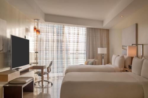 a hotel room with two beds and a flat screen tv at JW Marriott Panama in Panama City