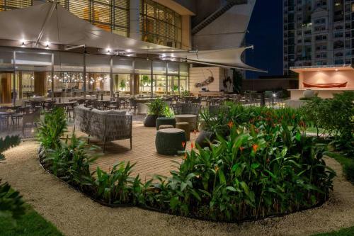 a restaurant with tables and chairs and plants at JW Marriott Panama in Panama City