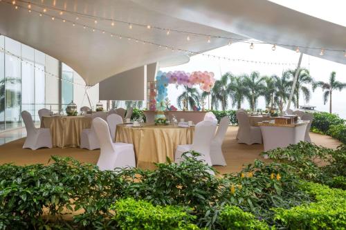 a banquet hall with tables and white chairs and lights at JW Marriott Panama in Panama City