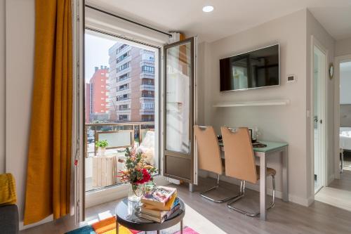 - un salon avec une table et une grande fenêtre dans l'établissement Apartamento Hospital Cruces - BEC, à Barakaldo