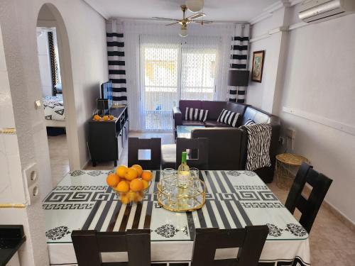 a living room with a table and a living room with a couch at Apartament Pinada Beach in La Mata