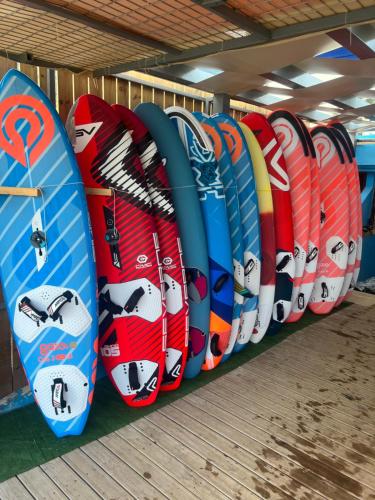 a row of surfboards lined up on a rack at Surf Hotel in Vasiliki