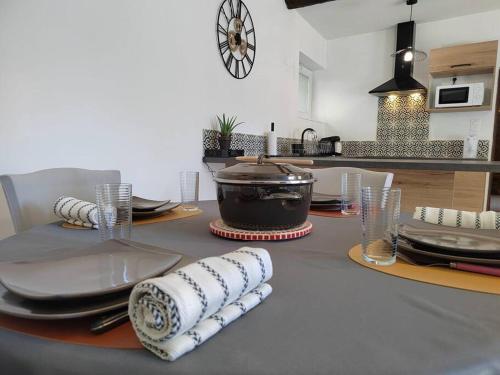 - une table avec des assiettes et des serviettes dans la cuisine dans l'établissement T2 la Voute Gontardaise, à Les Granges-Gontardes