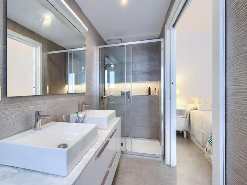 1 cama y baño con lavabo y ducha. en Bonito apartamento 2 minutos de la playa, en Fuengirola
