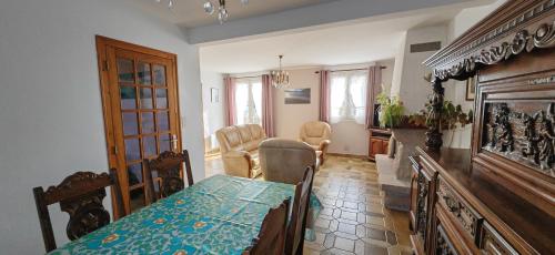 une salle à manger avec une table et des chaises et un salon dans l'établissement Belle maison proche de la plage, quartier calme, Audierne / Esquibien, à Audierne