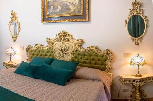 a bedroom with a bed with a green headboard at Il Mangia-Luxury in Siena