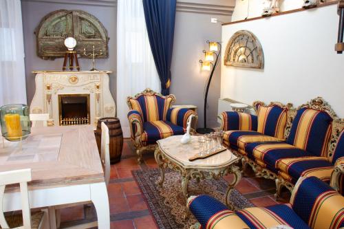 a living room with chairs and a table and a fireplace at Il Mangia-Luxury in Siena