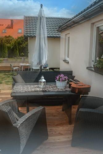 a table and chairs and an umbrella on a patio at Bajkowe Domki Marzeń Krecik in Węgorzewo