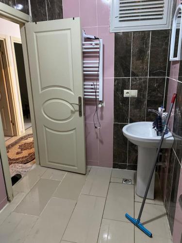 La salle de bains est pourvue d'une porte blanche et d'un lavabo. dans l'établissement Private Room in Istanbul #98, à Arnavutköy