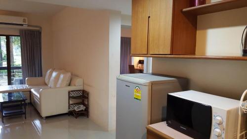 uma pequena cozinha com um frigorífico e uma sala de estar em Deluxe Suite Juldis Mansion 1 em Mu Si