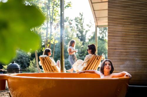 une femme assise dans une baignoire dans une cour dans l'établissement les Cabanes d'Ostende, à Ostende