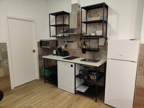 a kitchen with a white refrigerator and a sink at Apartamentos Pueblo Mar in Calpe