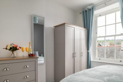 a bedroom with a dresser and a window at Glan Conwy House One and Two Bedroom Apartments in Llanrwst