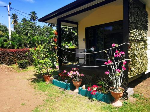 a house with pots of flowers in front of it at TAHITI - Orofero Lodge in Paea