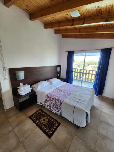 1 dormitorio con cama y ventana grande en Complejo Cielo Azul en Villa Rumipal