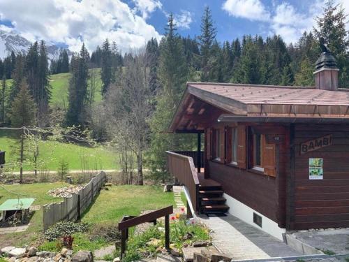 a small building with a bench in a field at Chalet Bambi in Sörenberg