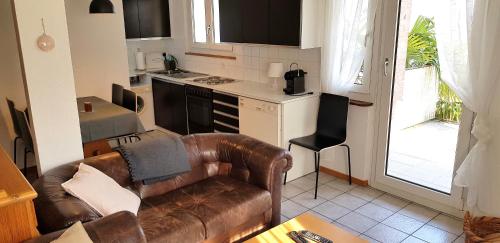 sala de estar con sofá y cocina en Casa Dina, en Lugano