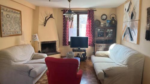 sala de estar con 2 sofás blancos y TV en Apartamento Bubal, en Panticosa