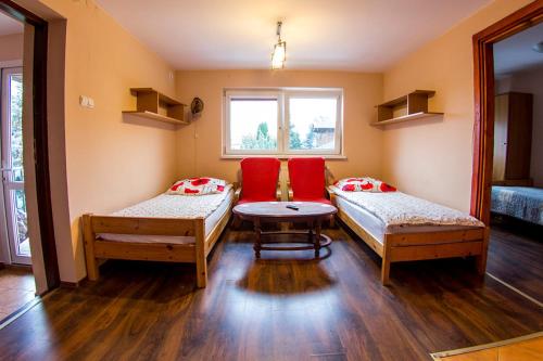 Pokój z 2 łóżkami, stołem i oknem w obiekcie noclegi pokoje gościnne kwatery pracownicze Dobranocka w mieście Sieradz