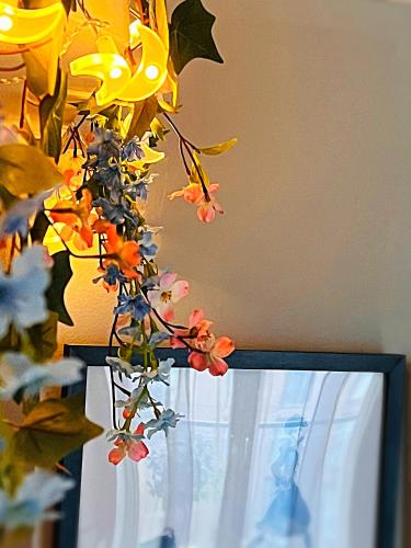 a vase filled with flowers next to a window at Latitude Chinatown Central Apartment in Birmingham