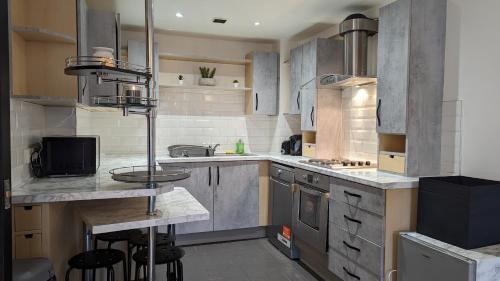 a large kitchen with stainless steel appliances and counters at JPG Theatre Suite - High Floor MCR Luxe Apartment w Balcony Canal Views in Manchester