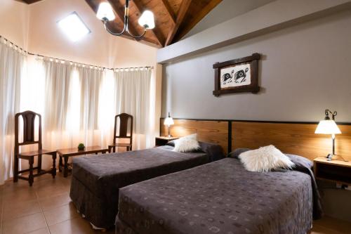 a hotel room with two beds and two chairs at Glaciares De La Patagonia in El Calafate