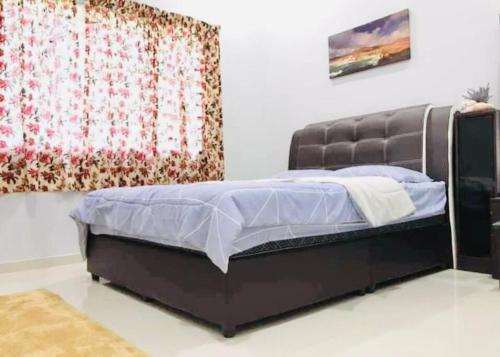 a bed in a room with a curtain at Kundang Villa @ Tasik Biru - 3 Bedrooms Bungalow in Rawang