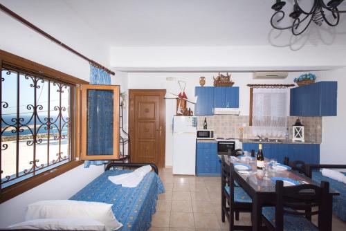 a kitchen with blue cabinets and a table with chairs at Irini Studios in Psarou