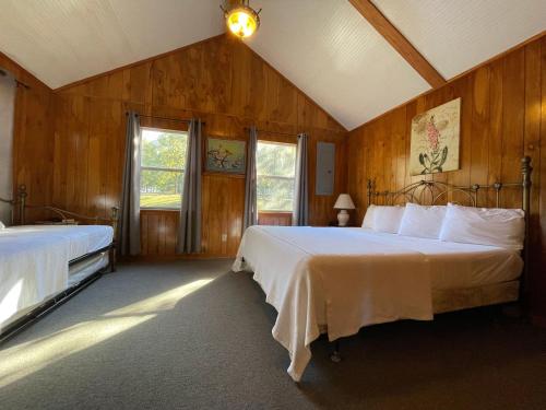 una camera da letto con due letti e due finestre di Wildwood Resort a Zwolle