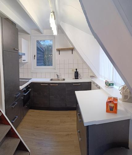 an attic kitchen with a sink and a window at Molière in Rekem