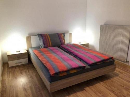 a bed with a colorful blanket on it in a room at Wohnung Chalet Veilchen in Herbriggen