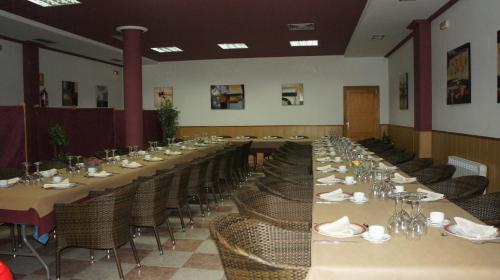 a large dining room with long tables and chairs at Hotel Puente Romano in Alcántara