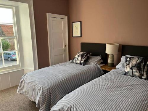 a bedroom with two beds and a window at Seahorses Crail in Crail